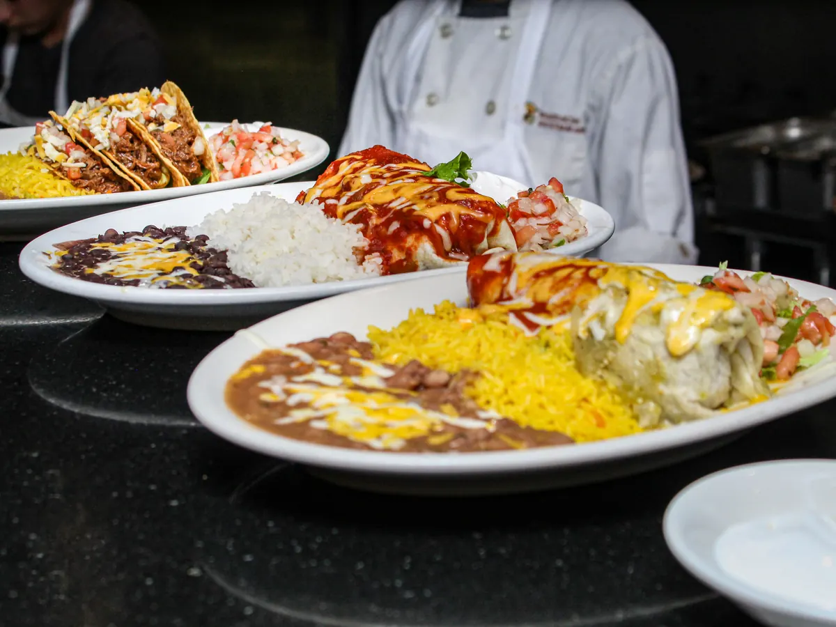 Plates of enchiladas and burritos at the kitchen pass