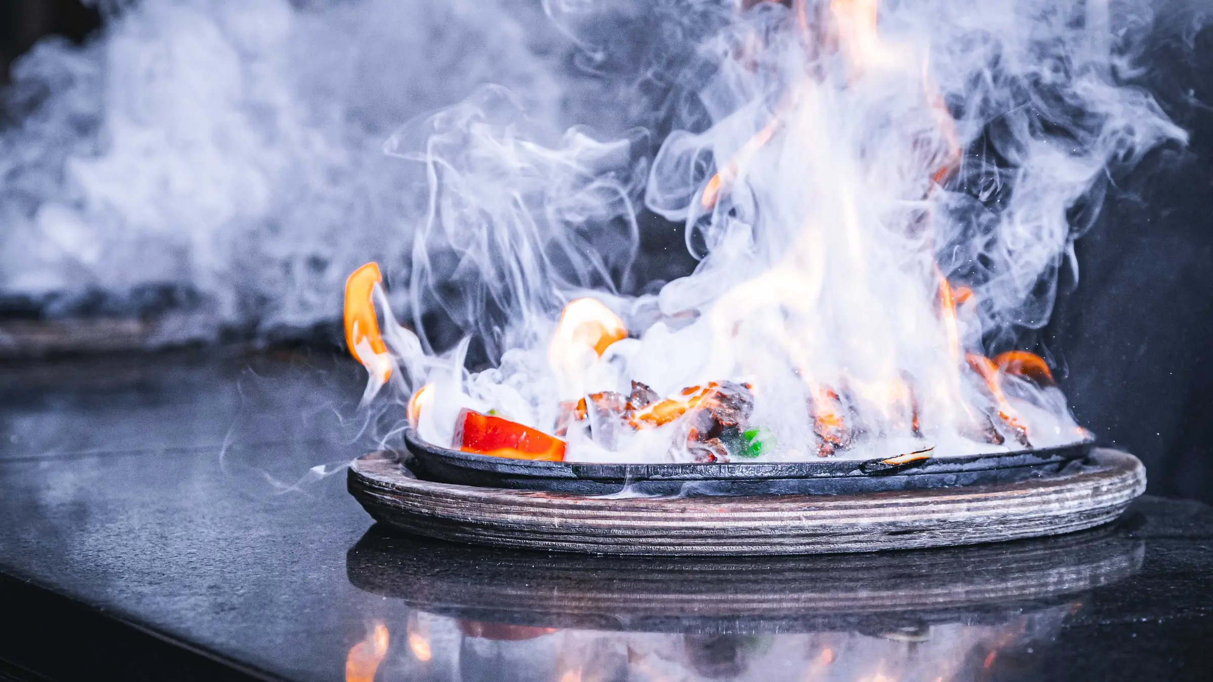 A fajita platter in flames on the grill