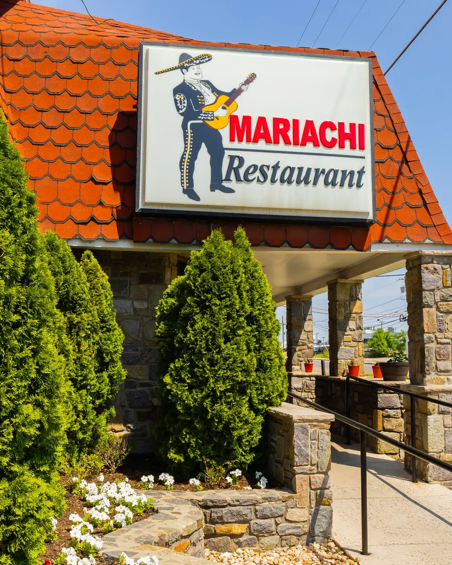 The Mariachi Restaurant sign, a mariachi with a guitar, over the front walk